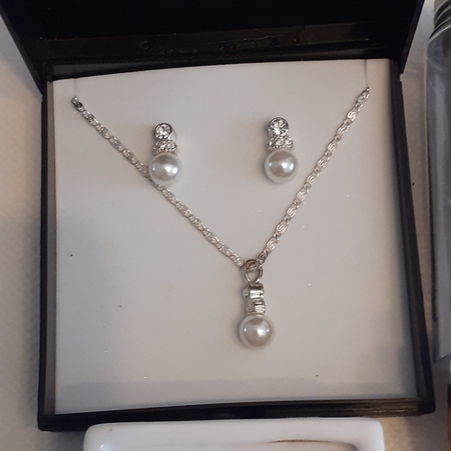 4 - Sets of faux pearls in presentation boxes. 2 x necklace and earrings set and an earrings set on its ... 