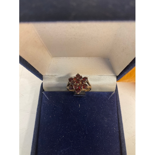 83B - 9ct gold dress ring with a floral cluster of red gem stones - 3grams of 9ct -  size I