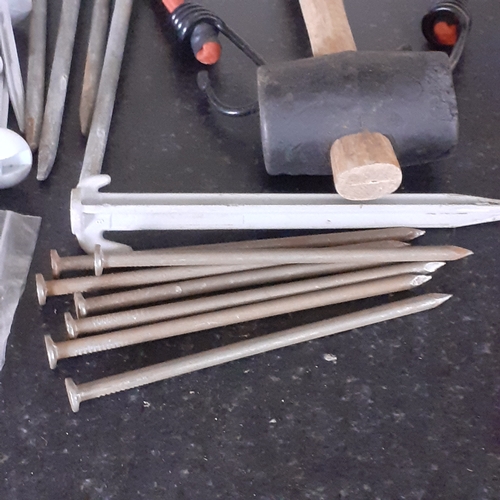 33 - Tent peg lot. Quantity of different size pegs with mallet covering anchoring needs for mostly style ... 