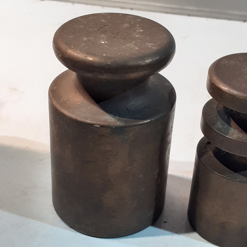 255 - Set of solid brass milk churn style weights. Range from 1kg down to 4oz. Seven weights in total