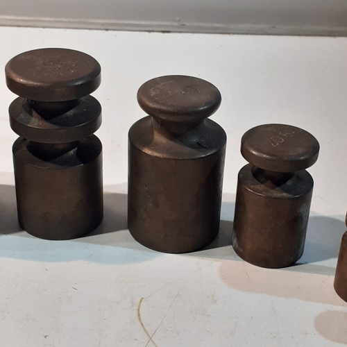 255 - Set of solid brass milk churn style weights. Range from 1kg down to 4oz. Seven weights in total