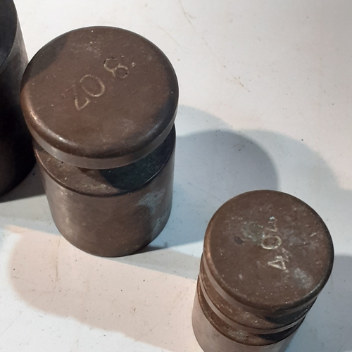 255 - Set of solid brass milk churn style weights. Range from 1kg down to 4oz. Seven weights in total