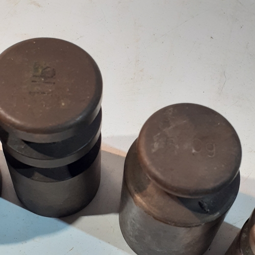 255 - Set of solid brass milk churn style weights. Range from 1kg down to 4oz. Seven weights in total