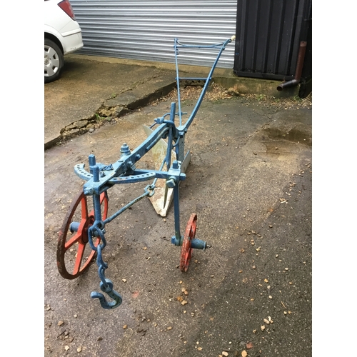 478 - Vintage Cooke manual push along plough - painted - wheels still move - approx 10ft long