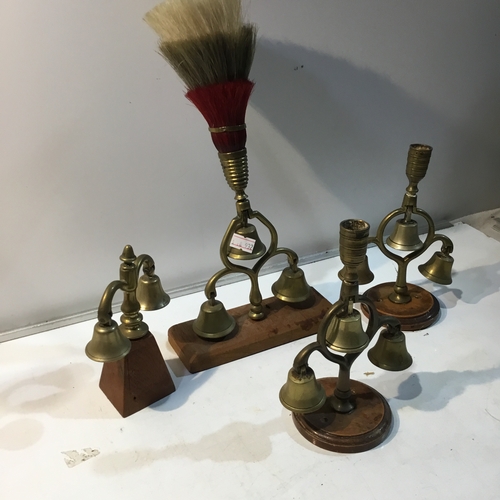 215 - Quantity of brass bell candlestick holders on wooden plinths