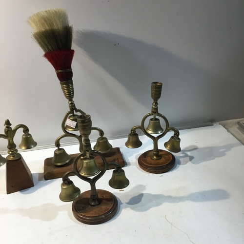 215 - Quantity of brass bell candlestick holders on wooden plinths