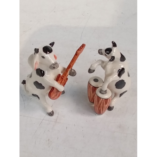 251 - 2 small pottery cow ornaments with one playing Bongos and the other the guitar. Nice detail and no d... 