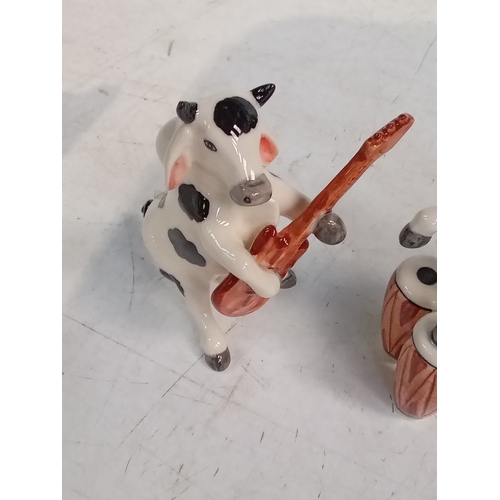 251 - 2 small pottery cow ornaments with one playing Bongos and the other the guitar. Nice detail and no d... 