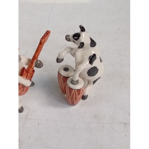 251 - 2 small pottery cow ornaments with one playing Bongos and the other the guitar. Nice detail and no d... 