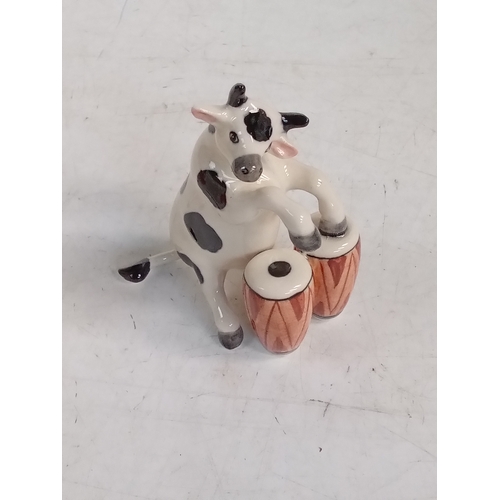 251 - 2 small pottery cow ornaments with one playing Bongos and the other the guitar. Nice detail and no d... 