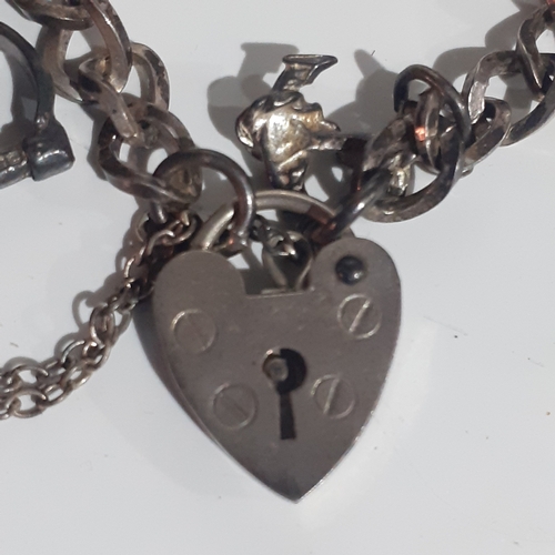 53B - Sterling silver padlock charm bracelet with 2 charms. Clasp works fine. Wood benefit a clean.  Weigh... 