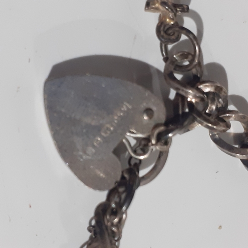 53B - Sterling silver padlock charm bracelet with 2 charms. Clasp works fine. Wood benefit a clean.  Weigh... 