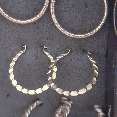5 - Several pairs of gold coloured metal earrings. Mostly drop hoops with one pair of studs. Nice condit... 