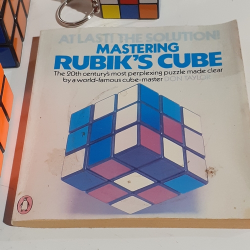 4 - 2 genuine Rubiks cubes, a keyring Rubiks and a solution/instruction book. Very nice clean condition.