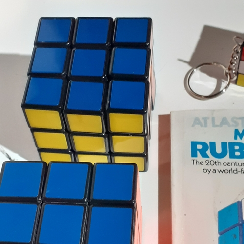 4 - 2 genuine Rubiks cubes, a keyring Rubiks and a solution/instruction book. Very nice clean condition.