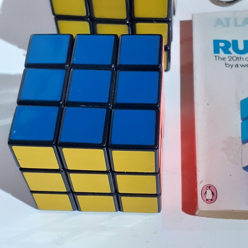 4 - 2 genuine Rubiks cubes, a keyring Rubiks and a solution/instruction book. Very nice clean condition.