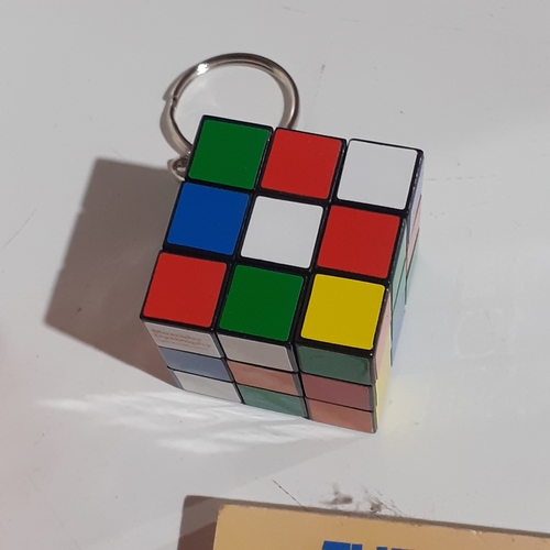 4 - 2 genuine Rubiks cubes, a keyring Rubiks and a solution/instruction book. Very nice clean condition.