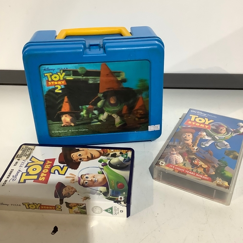 262 - Toy story2 lunch box + toy story1 + 2 vhs videotapes