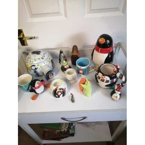 60A - Large collection of penguin related items including biscuit barrel, mugs and condiment set