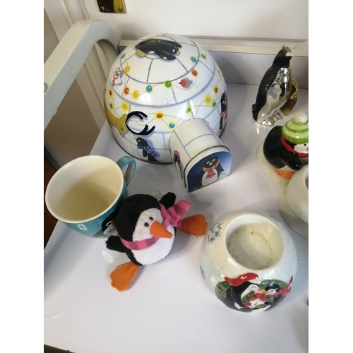 60A - Large collection of penguin related items including biscuit barrel, mugs and condiment set