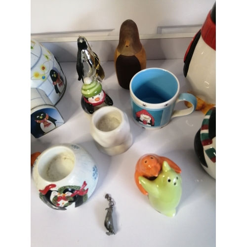 60A - Large collection of penguin related items including biscuit barrel, mugs and condiment set