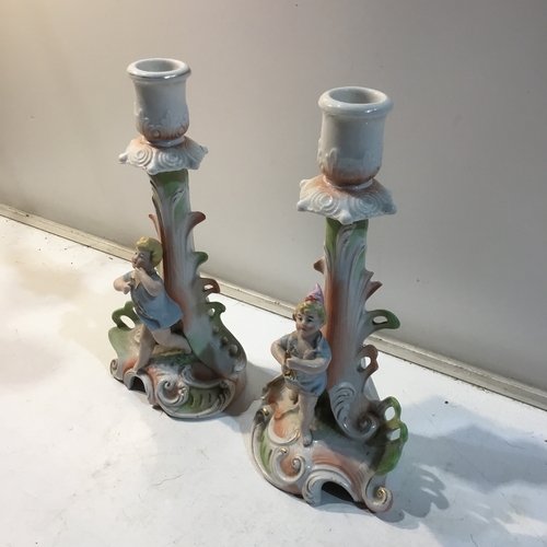 142 - Pair of cherub style porcelain candle stick holders