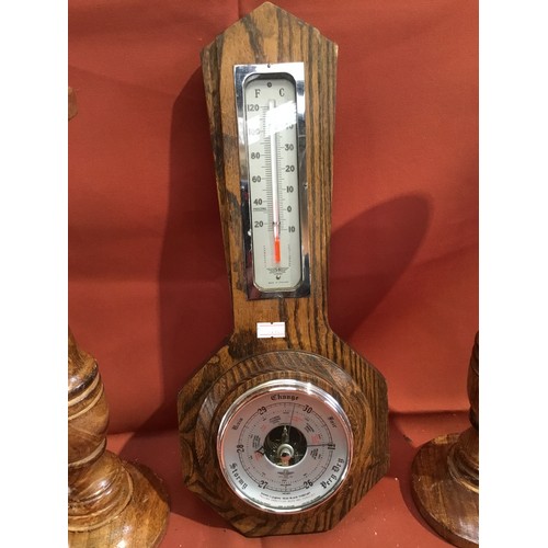 244 - Pair of wooden candle holders and oak cased barometer