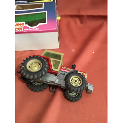 212 - Battery operated remote control farm tractor in box and two other die cast tractors with plastic cab... 