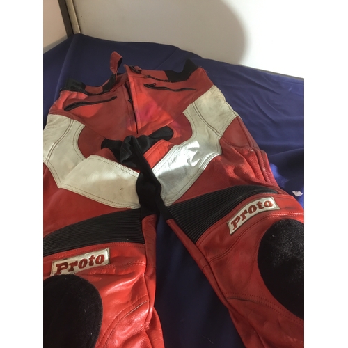 481 - A pair of red leather motorcycle trousers and open faced black Frank Thomas helmet