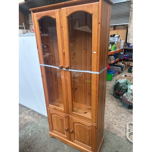 525 - Pine Glass Cabinet with cupboard and three glass shelves in good condition.