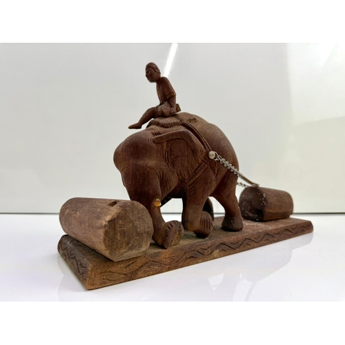 73 - Wooden carved sculpture of an elephant in a tiring working position