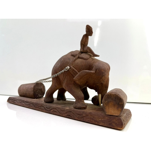 73 - Wooden carved sculpture of an elephant in a tiring working position