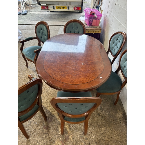 253 - Polished oval dining table with rich wood finish and ornate pedestal base. Paired with six tufted, u... 