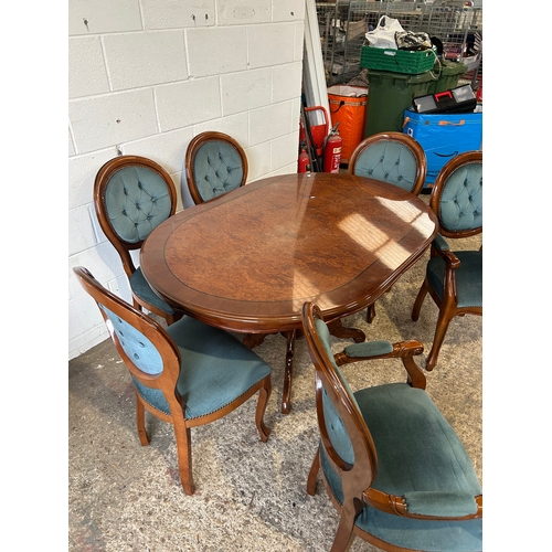 253 - Polished oval dining table with rich wood finish and ornate pedestal base. Paired with six tufted, u... 