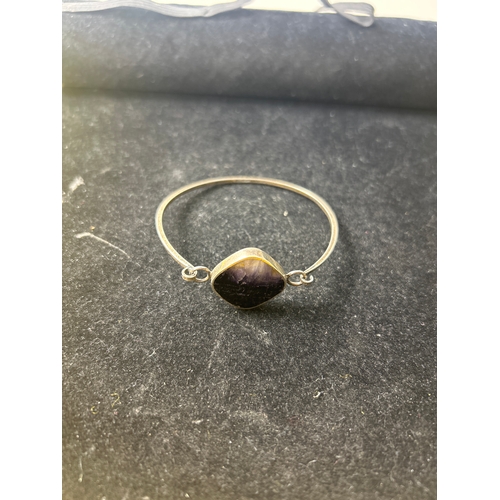 16 - Sterling silver bangle, ring (size O) and earrings with decorative purple & clear central stone set ... 