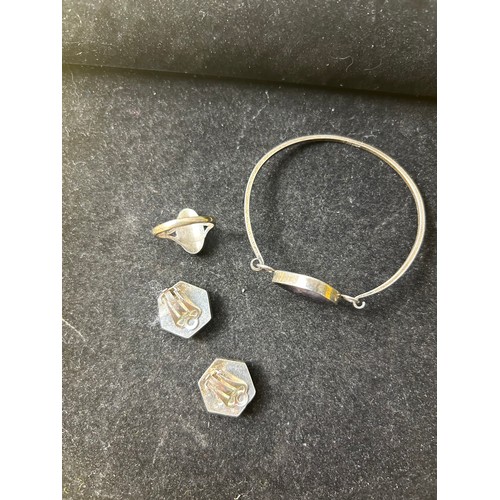 16 - Sterling silver bangle, ring (size O) and earrings with decorative purple & clear central stone set ... 