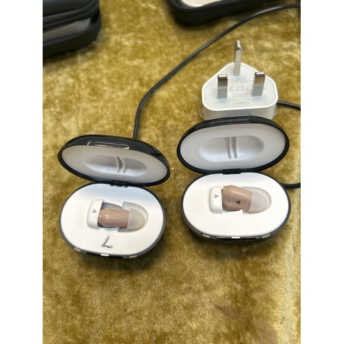 24 - Pair of micro infini-ear hearing aids with cases & chargers