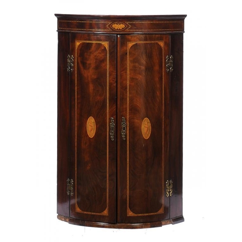 1379 - A GEORGE III MAHOGANY BOW FRONTED CORNER CUPBOARD, EARLY 19TH C  inlaid with butterfly and shell pat... 