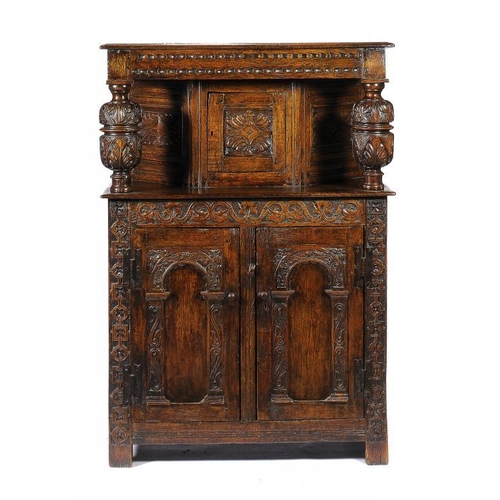 1395 - A CARVED OAK LIVERY CUPBOARD, EARLY 20TH C  with panelled sides, iron H hinges, 139cm h; 47 x 96cm... 