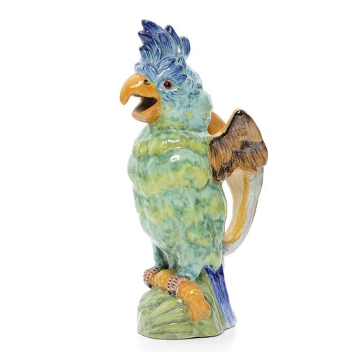 243 - A MOSANIC FAIENCE COCKATOO NOVELTY JUG, C1900 in brightly coloured glazes, with glass eyes, 31cm h, ... 