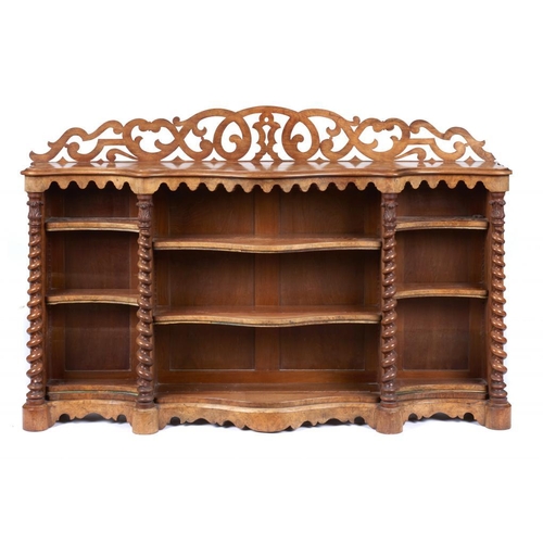 934 - A VICTORIAN SERPENTINE WALNUT OPEN BOOKCASE, C1870  with fretwork back and tapering spiral pillars, ... 