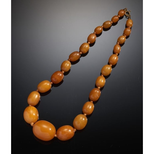 99 - A NECKLACE OF TWENTY FOUR AMBER BEADS 38g