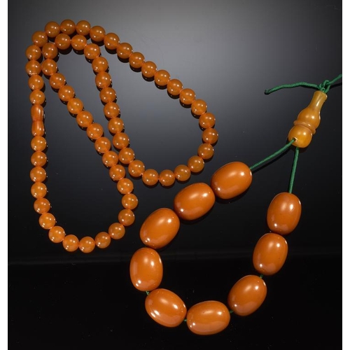 99A - A NECKLACE OF FIFTY NINE RECONSTRUCTED AMBER BEADS, 53G, AND A NECKLACE OF NINE LARGER AMBER TYPE IS... 