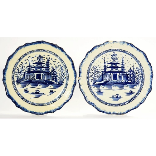 126 - TWO PEARLWARE PLATES, PAINTED IN COBALT WITH A TEMPLE AND FENCE PATTERN, IN FEATHERED RIM, 20.5 AND ... 