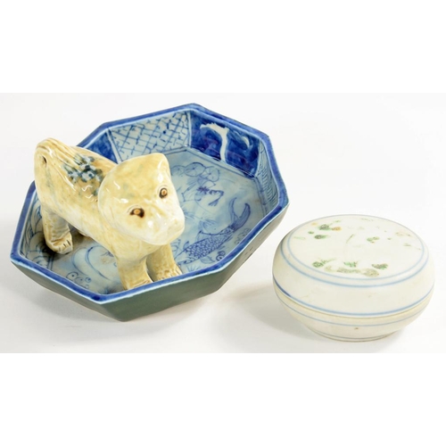 132 - A CHINESE PORCELAIN BOX AND COVER AND A JAPANESE PORCELAIN FIGURE OF A DOG ON A DISH, PAINTED IN BLU... 