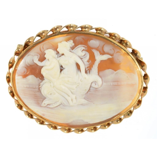 19 - A CAMEO BROOCH, THE OVAL SHELL CARVED WITH CLASSICAL FIGURES ON A DOLPHIN, GOLD MOUNT