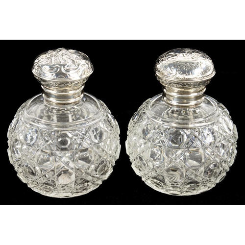 71 - A PAIR OF CUT GLASS SPHERICAL SCENT BOTTLES, WITH ORNATE EMBOSSED SILVER SCREW-CAP, 11CM H, APPARENT... 