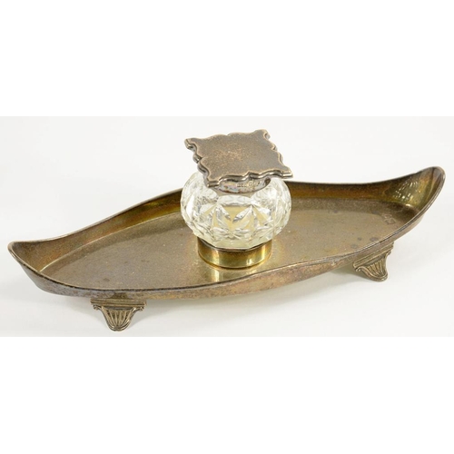 81 - A VICTORIAN SILVER MOUNTED CUT GLASS INKWELL, ON BOAT SHAPED TRAY, 21CM W, LONDON 1897