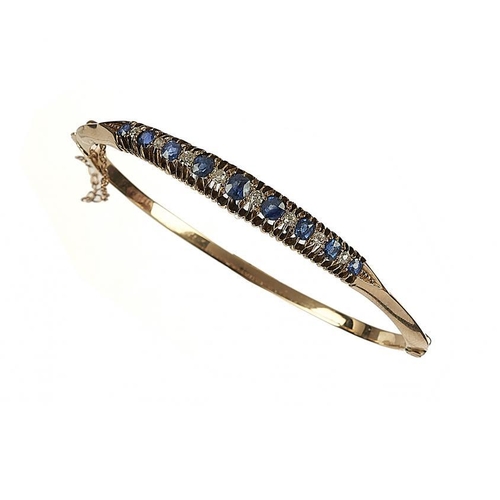 69 - A SAPPHIRE AND DIAMOND BANGLE  the nine sapphires interspersed with evenly sized old cut diamonds, i... 