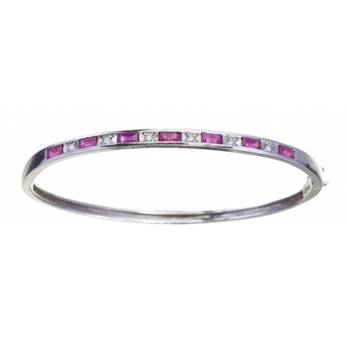 79 - A RUBY AND DIAMOND BANGLE in white gold, 53 x 63mm, foreign control marks including 750, 10g... 